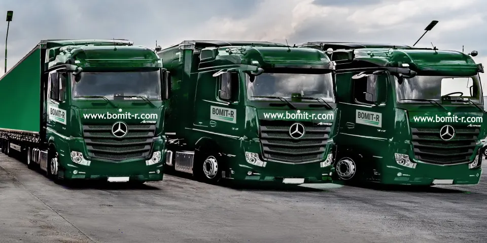 Tri tamnozelena tegljača Mercedes-Benz Actros sa ciradama i natpisom www.bomit-r.com, parkirana jedan uz drugi.